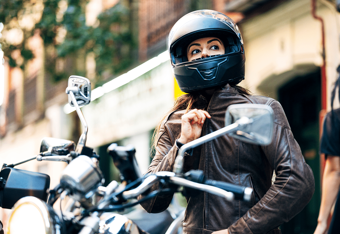 Hero_Seguro-moto_Mobile Chica montada en una moto, cerrando la cremallera de su chaqueta