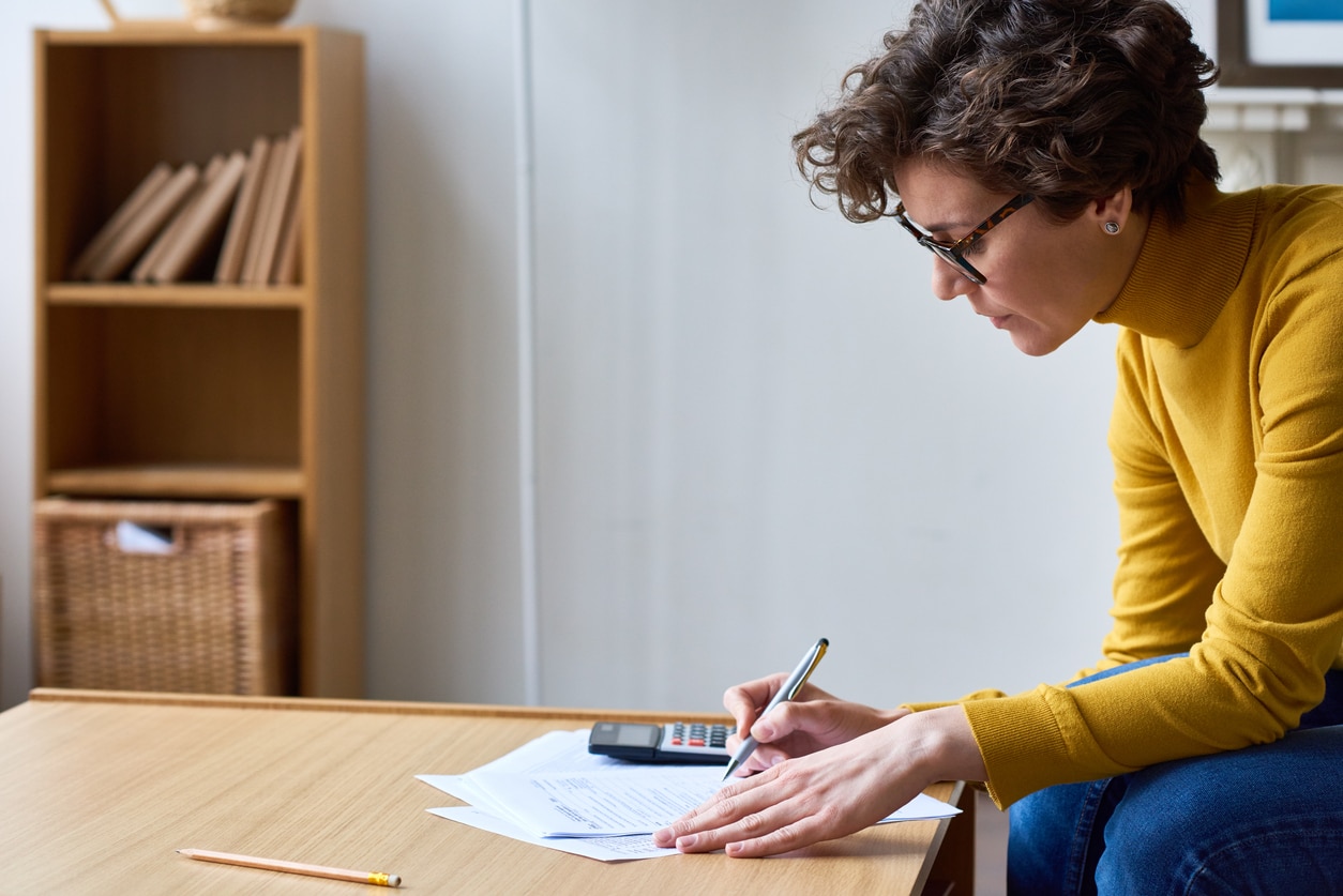 Concentrated woman filling documents at home