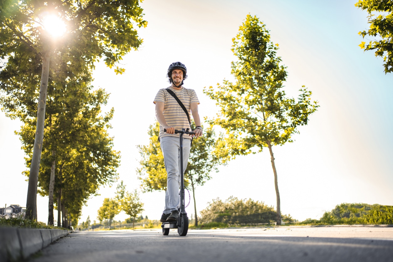 Hombre con casco protector mientras monta su e-scooter