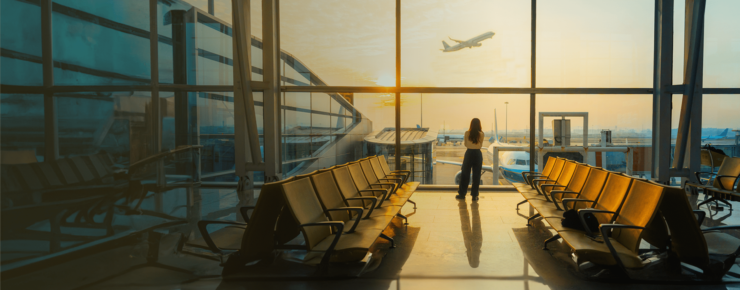 seguro-anulacion BANNER A young woman is using a smartphone to check the arrival departure board and flight schedule at the airport. - Fotografía de stock