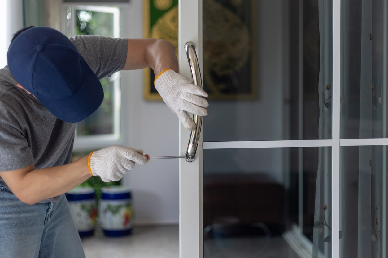 Worker install handle on aluminium swing door. cerrajero seguro de hogar
