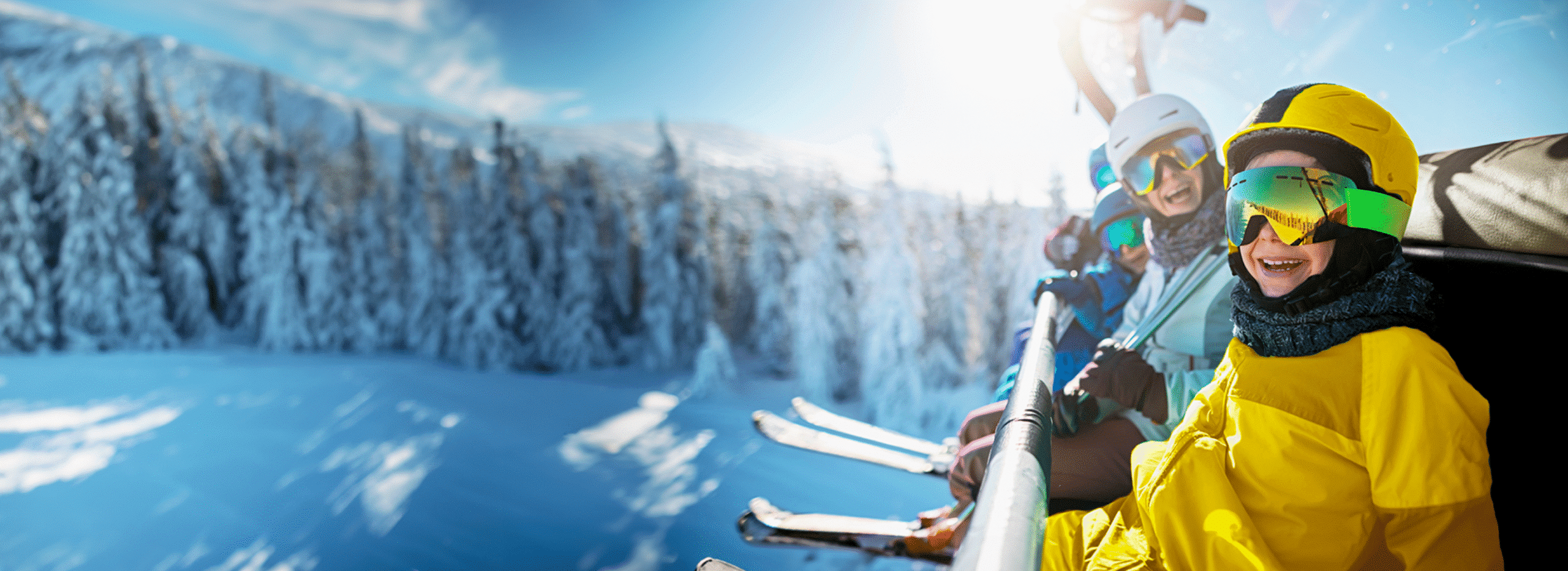 Familia sonriendo en el telesilla de una pista de esquí